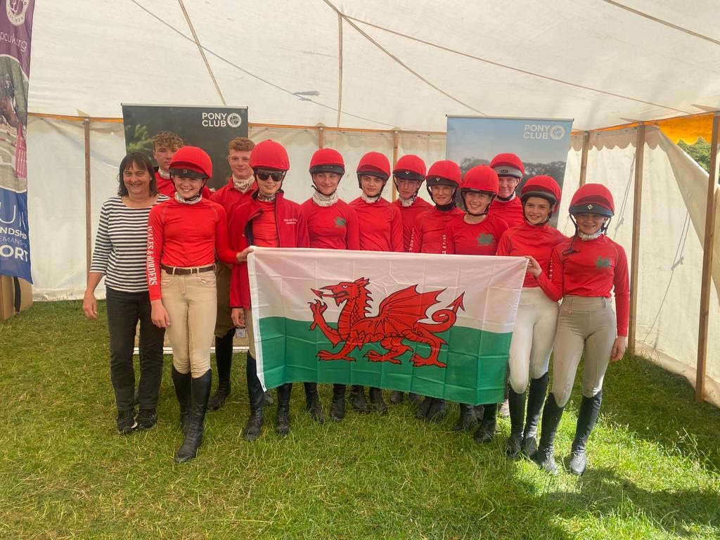 Abby, Sophie, Eva and their club holding the Welsh flag